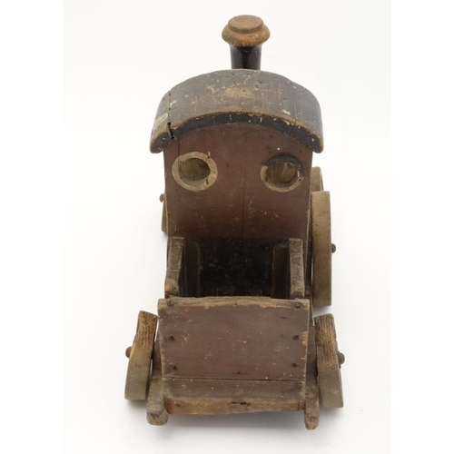 397 - Toy: An early 20thC large wooden hand made toy steam train , having green painted boiler and black c... 