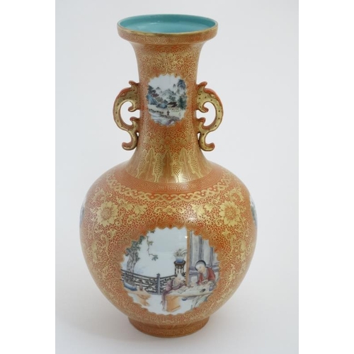 402 - An early 20thC burnt orange twin handled bottle vase , having decorative panels with figures and lan... 