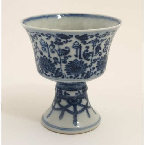 404 - A Chinese blue and white stem cup , the outside decorated with stylised chrysanthemums and symbols ,... 