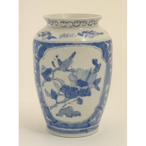 406 - An Oriental blue and white vase decorated with exotic birds and flowers. 8'' high.