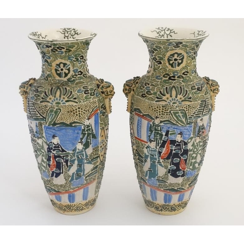 408 - A pair of Japanese Satsuma Moriage twin handled vases, each decorated in polychrome with figures , t... 