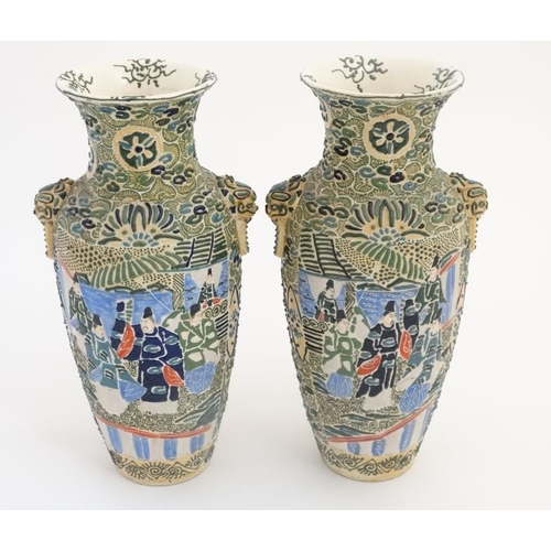 408 - A pair of Japanese Satsuma Moriage twin handled vases, each decorated in polychrome with figures , t... 