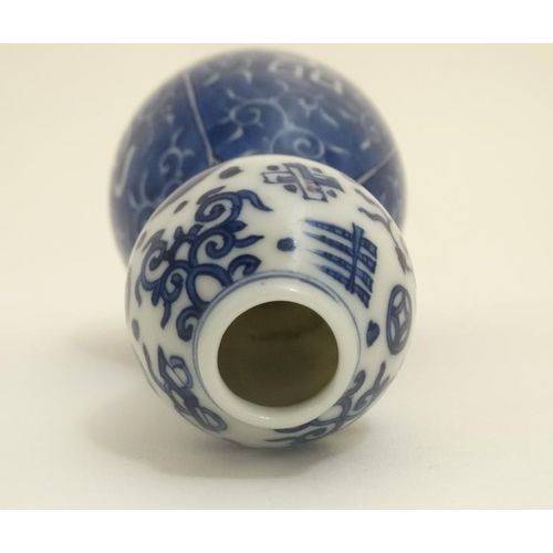 409 - A Chinese blue and white double gourd vase , decorated with scrolling foliage and Oriental symbols. ... 