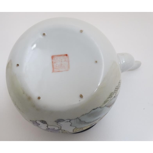 410 - A Chinese famille rose teapot decorated with figures seated under a tree, script to reverse and the ... 