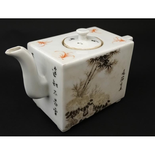 423 - A Chinese square form teapot, decorated to sides with bamboo and cherry blossom  in shades of black ... 