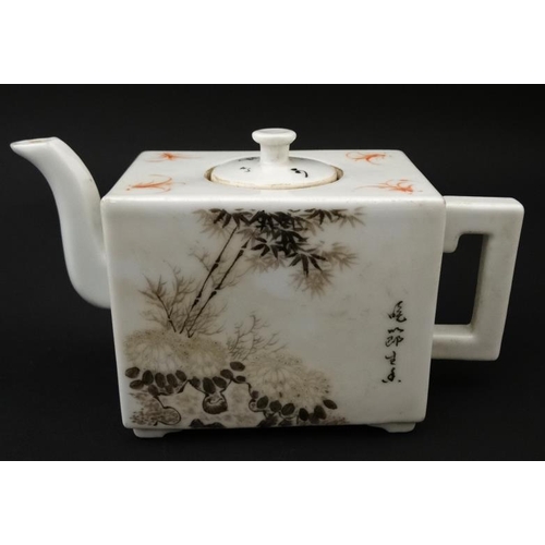 423 - A Chinese square form teapot, decorated to sides with bamboo and cherry blossom  in shades of black ... 