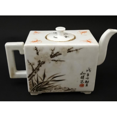 423 - A Chinese square form teapot, decorated to sides with bamboo and cherry blossom  in shades of black ... 