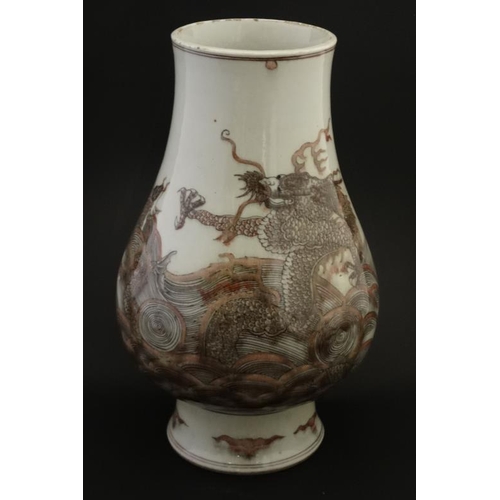 427 - A Chinese copper red and black on white vase , decorated with 4 clawed dragon and fish amongst rolli... 