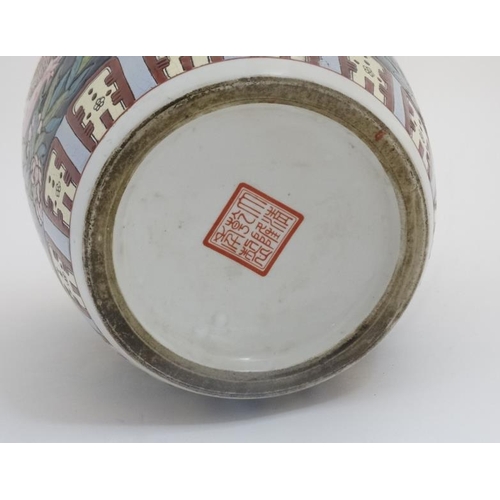 437 - A Chinese ginger jar and cover decorated with pink pomegranates and leaves on a navy ground, bears r... 