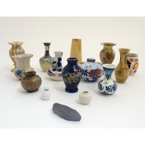 439 - A collection of 14 small and miniature vases to include blue and white delft , Oriental, wooden and ... 