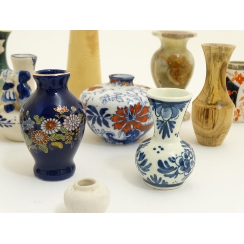 439 - A collection of 14 small and miniature vases to include blue and white delft , Oriental, wooden and ... 