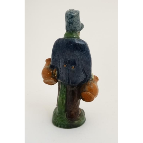 444 - A Belgian Studio pottery figure of a man carrying jugs, 9'' high.