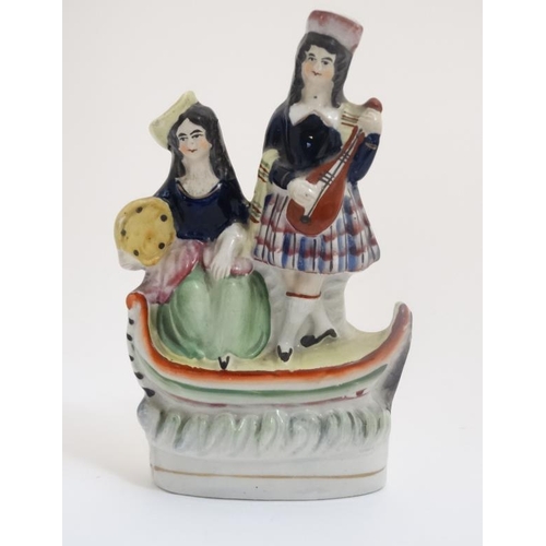 451 - A 19thC Staffordshire figure group formed as two Scottish Musicians aboard a boat. 7 3/4'' high.