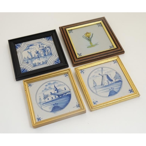 464 - A collection of four framed blue and white Delft tiles to include images of a tulip, a windmill, a l... 