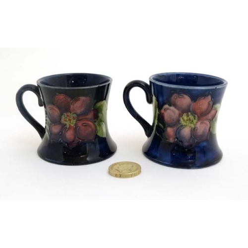 472 - A pair of Moorcroft Miniature ' Clematis ' pattern tankards on a cobalt blue ground , one bears orig... 