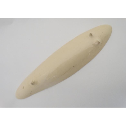 480 - An elongated ceramic dish decorated with musical notes in cream on a green ground. 16'' long.