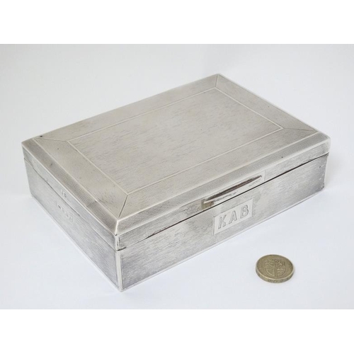 512 - An Art Deco silver table top cigarette box with engine turned decoration. Hallmarked Birmingham 1936... 