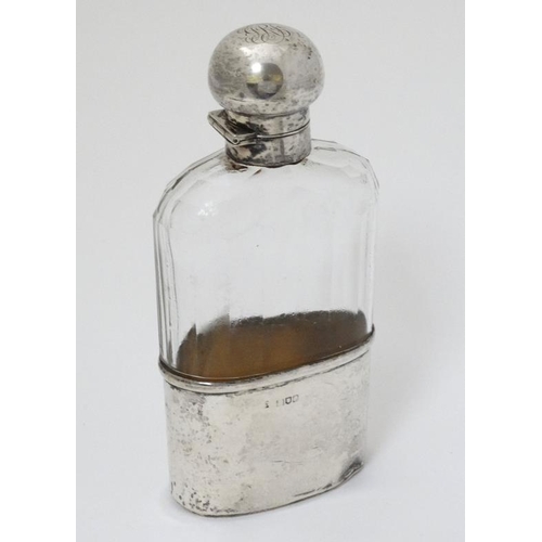 524 - A cut glass hip flask with silver beaker to lower section an silver mounts and top, hallmarked Londo... 