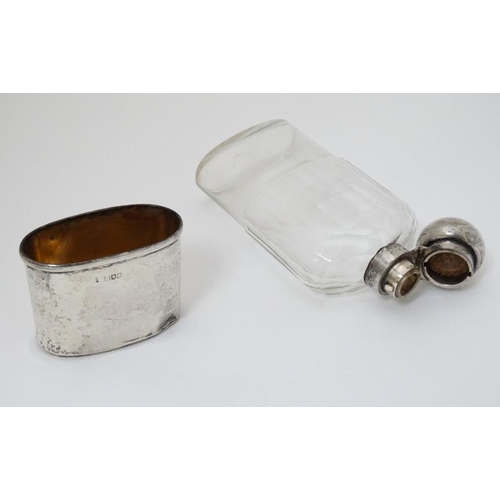 524 - A cut glass hip flask with silver beaker to lower section an silver mounts and top, hallmarked Londo... 