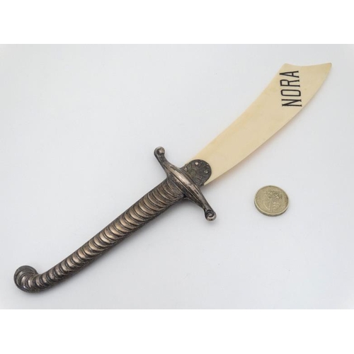 555 - A Victorian paper knife / page turner formed as a sabre, with silver handle and ivory blade marked '... 