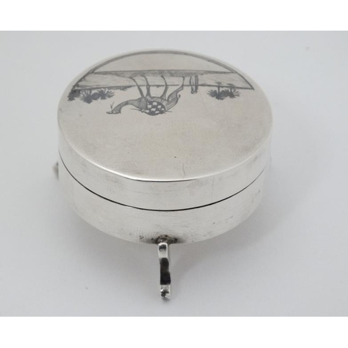 561 - A white metal pot and cover on three shaped feet and with niello like decoration to lid depicting a ... 