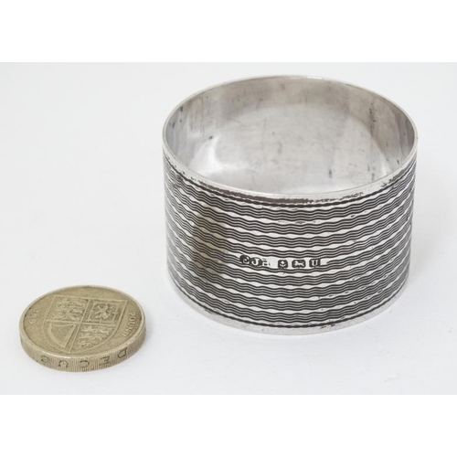 574 - An Art Deco silver napkin ring with engine turned decoration Hallmarked Birmingham 1944 maker E J Ho... 