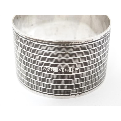 574 - An Art Deco silver napkin ring with engine turned decoration Hallmarked Birmingham 1944 maker E J Ho... 