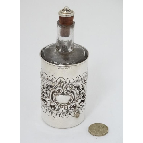 590 - A glass cologne bottle with embossed and pierced silver cover hallmarked Birmingham 1904 maker Willi... 