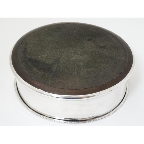 605 - A silver bottle coaster with turned wooden base hallmarked Birmingham 1992 maker   P H Vogel & Co. 4... 