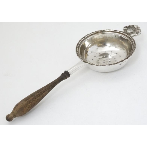 619 - A silver tea strainer with turned wooden handle. hallmarked Sheffield 1988 maker Francis Howard Ltd.