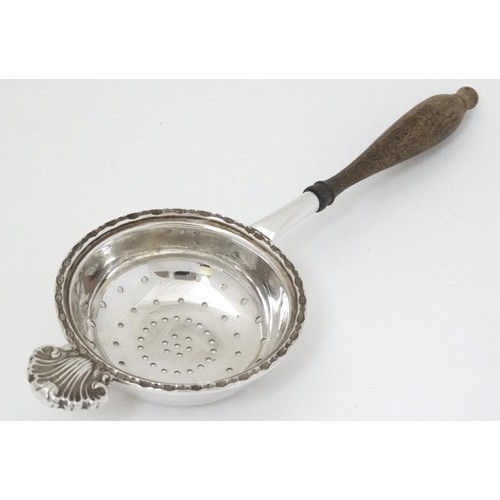 619 - A silver tea strainer with turned wooden handle. hallmarked Sheffield 1988 maker Francis Howard Ltd.