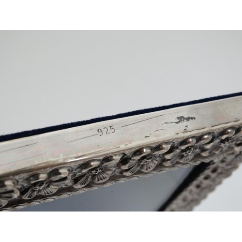 635 - A white metal photograph frame with floral  decoration, marked '925'  with easel / strut back. The w... 