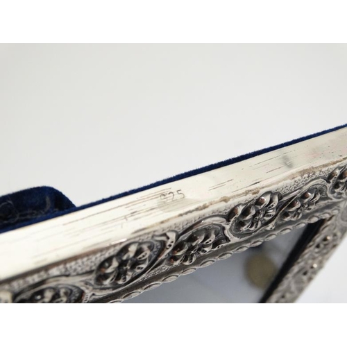 636 - A white metal photograph frame with floral and scroll decoration, marked '925'  with easel / strut b... 