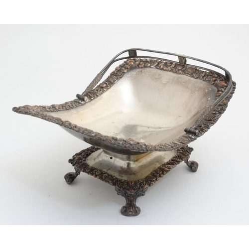 641 - An old Sheffield plate cake basket with scallop floral and foliate decoration to border and swing ha... 