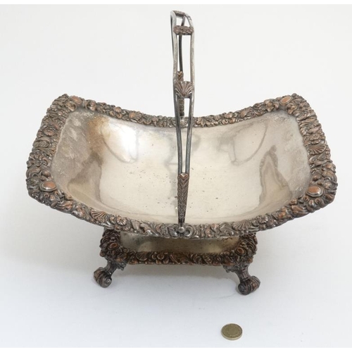 641 - An old Sheffield plate cake basket with scallop floral and foliate decoration to border and swing ha... 