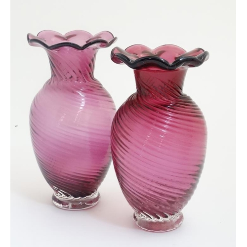 647 - A matched pair of cranberry glass vases with flared rims. The tallest 9'' high