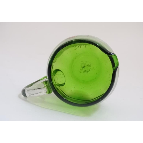 654 - A green glass jug with clear glass loop handle and Mary Gregory style decoration. 3 1/2'' high