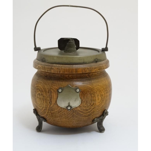 706 - A circa 1900 oak and silver plate three footed Biscuit Barrel , with swing over handle , named plaqu... 