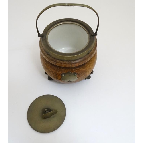 706 - A circa 1900 oak and silver plate three footed Biscuit Barrel , with swing over handle , named plaqu... 