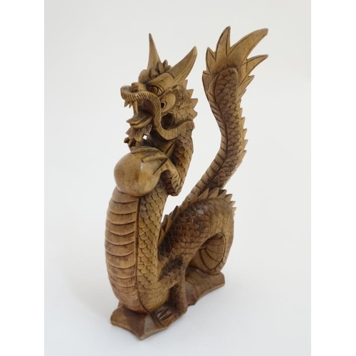 775 - A 21stC carved wooden dragon rearing holing pearl of wisdom 12 1/4'' high