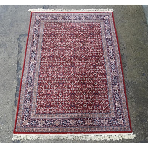 79 - Rug / Carpet :  a 20 thC Belgian Wilton rug with wine ground and 3 band borders,  100 x 65 1/2''