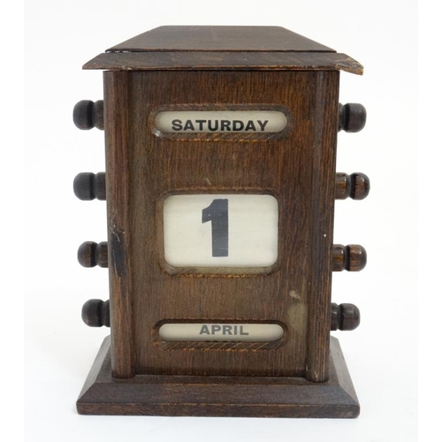 791 - A 1920's oak desk calendar having day date and month apertures 6 1/2'' high x 4 7/8'' wide