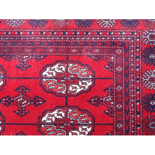 80 - Rug / Carpet :   A large woollen Bokara Rug with wine red ground , 133 (7x19) boteh to middle , Rug ... 