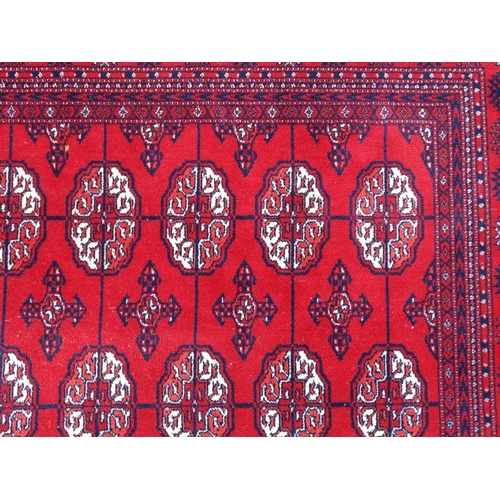 80 - Rug / Carpet :   A large woollen Bokara Rug with wine red ground , 133 (7x19) boteh to middle , Rug ... 