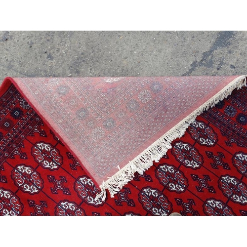 80 - Rug / Carpet :   A large woollen Bokara Rug with wine red ground , 133 (7x19) boteh to middle , Rug ... 