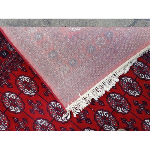 80 - Rug / Carpet :   A large woollen Bokara Rug with wine red ground , 133 (7x19) boteh to middle , Rug ... 