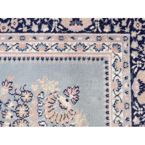 81 - Rug / Carpet :   A woollen machine made carpet  in blue and pink with 3 bands measuring 135 x 94