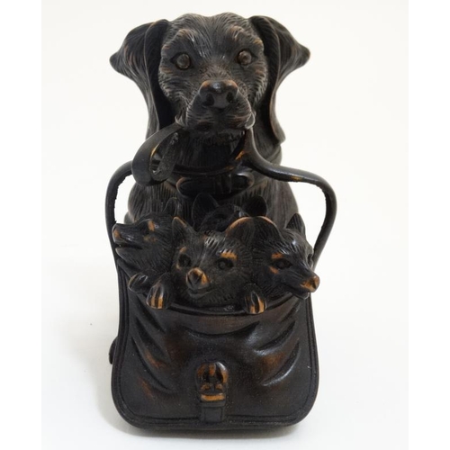 813 - A 21st carved black forest inkwell formed as a dachshund dog with hinged head and holding a satchel ... 