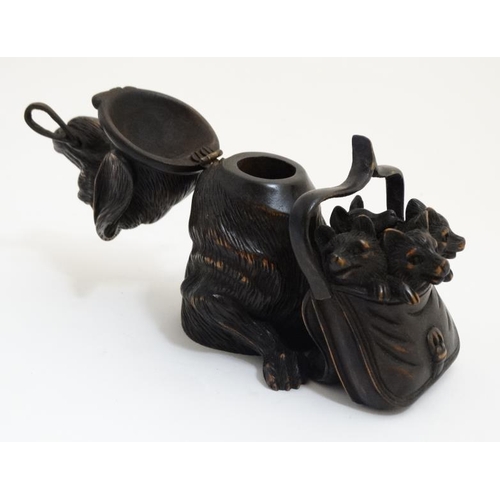 813 - A 21st carved black forest inkwell formed as a dachshund dog with hinged head and holding a satchel ... 