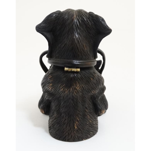 813 - A 21st carved black forest inkwell formed as a dachshund dog with hinged head and holding a satchel ... 